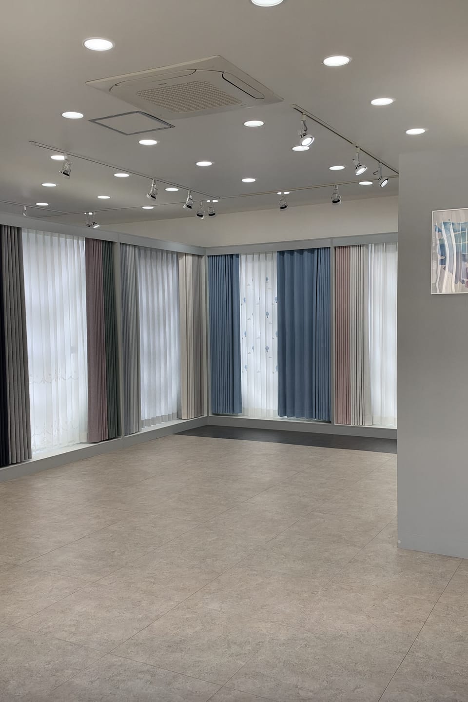양주 전시장 내부, 넓은 바닥을 따라 커튼과 유니커버스가 실제 창 크기로 걸려 있는 모습